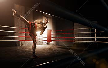 Young man kickboxing in the Arena