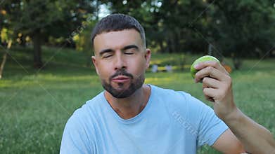 Video of healthy man eating an apple in nature