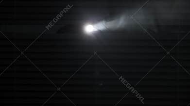 search for a criminal, a man with a flashlight in his hands shines through blinds in a dark room against the background