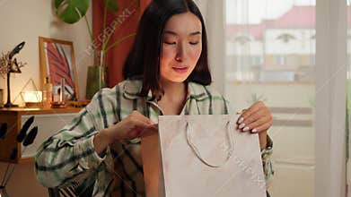 Happy Asian Korean Chinese Japanese woman looking package purchase gift glowing female amazement emotions surprise