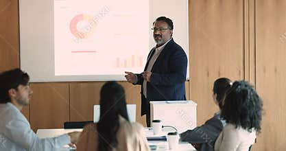 Mature Indian business leader man giving workshop, marketing seminar