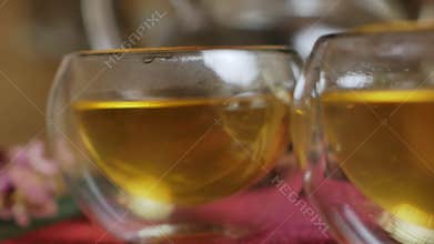The video shows closeups of tea cups on a table, creating warmth. Media