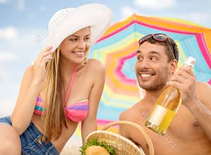 Smiling couple having picnic on the beach