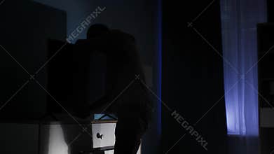 Adult man in balaclava puts tv on dresser closes closet and leaves late at night
