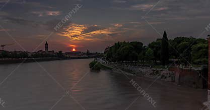Cityscape view from Castelvecchio castle bridge. Sunset on the background, Adige river on the