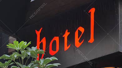 Stylish Hotel Sign Featuring Bold Typography Alongside Lush Greenery