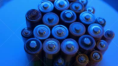 Rotating close-up view of depleted batteries illuminated by blue light