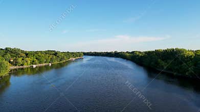 Landscape drone over the Mississippi River with grass lawns and blue sky on the horizon