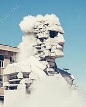 A statue of a man with a beard and a beard is being blown up