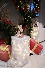 Chrismast decoration details with green leafy plants, gift boxes, owl and reindeer toy
