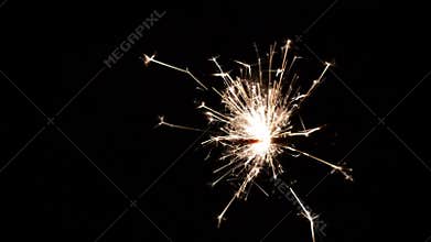 Burning sparkler on black background.