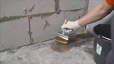 Construction worker applying waterproofing membrane on concrete floor