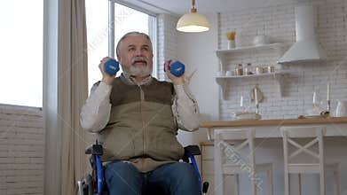 Motivated senior man in wheelchair doing dumbbell shoulder press in care home