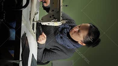 Seamstress cuts and burns threads edges on leather detail