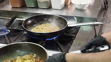 Chef adding chicken to chickpeas in a pan