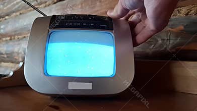 Old retro TV with static noise on screen in dark room.