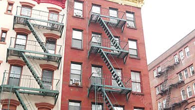 New York City building architecture, Manhattan. Residential house exterior. Red brick, fire escape.