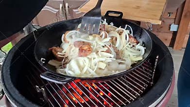 Preparation of traditional pilaf: frying meat and onions in a cauldron over an open fire.