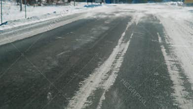 Snowy Road Conditions with Unique Wind Patterns Affecting the Asphalt Surface in Winter Drive Scenarios