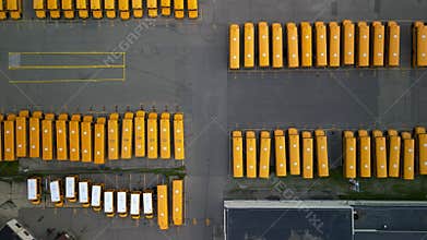 Top down view of rows of school buses in open garage storage yard during school holiday time