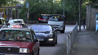 Lively traffic scene showcasing cars, bus, taxi and truck going on street in Hong Kong