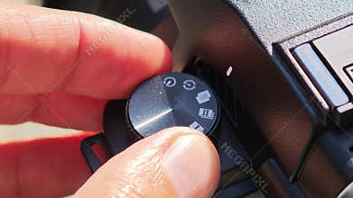 Videographer turning mode dial on professional video camera