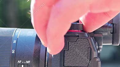 Close up of a videographer's hands adjusting focus and other settings on a professional camera