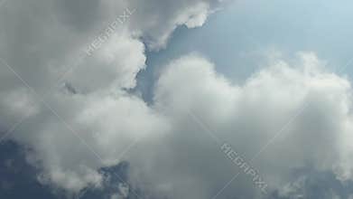 Fluffy white clouds slowly drift across the blue daytime sky. beautiful clouds moving. Airy snow-white clouds moved to the side.