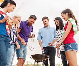 Group of friends making barbecue on the beach