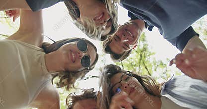Young Carefree Friends Look Down and Smile at the Camera, Sharing Happy Moments