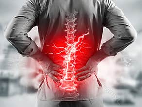 High-resolution image of a professional in profile, standing with hands clasped over lower back, showing lumbar discomfort Red