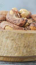 vertical shot of cashew nuts in a wooden bowl