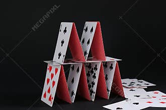 House of playing cards on black background
