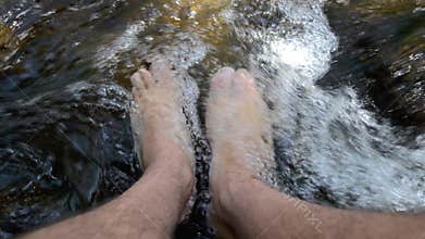 Man wash his legs in fresh spring water