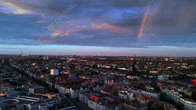 Rainbow over Berlin cityscape at golden hour. Magic aerial view flight drone