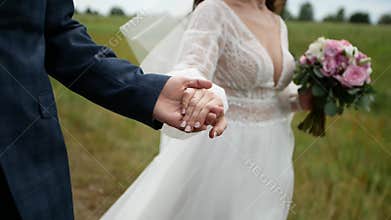 groom is leading the beautiful bride holding her hand