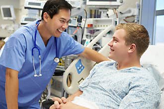 Young Male Patient Talking To Male Nurse In Emergency Room