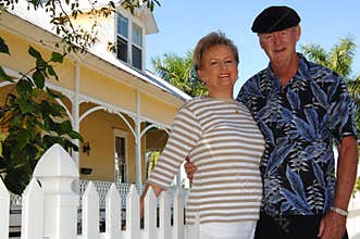 Senior couple in front of house