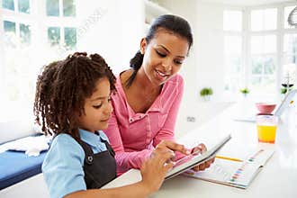 Mother And Child Using Digital Tablet For Homework
