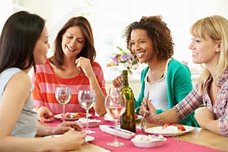 Group Of Women Sitting Around Table Eating Dessert