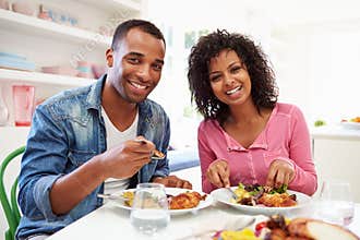 Young African American Couple Eating Meal At Home