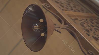 Low angle footage of old-designed lamp with metal funnel installed in a wooden bar
