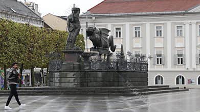 Historical Lindwurmbrunnen fountain at Neuer Square, on a rainy day, in Klagenfurt, Austria
