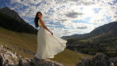 Beautiful bride in long white dress in nature