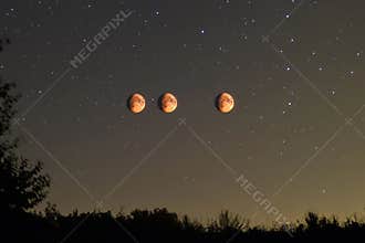 Three full moons shining brightly in a starry night sky