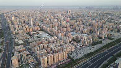 Aerial Urban Scenery Captured Above Hawalli City Plus A Panoramic Skyline Of Kuwait City In The Distance