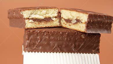 Two chocolate cakes are stacked on top of each other, one is cut in half and