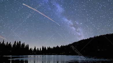 Magical Night Lake Timelapse Featuring the Milky Way, Falling Stars, and a Silhouetted Pine Forest.