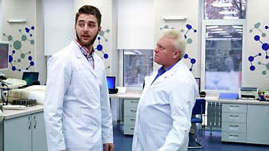 Two male scientists greet each other at the laboratory