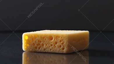 A piece of cheese sits alone on a table, waiting to be served or consumed